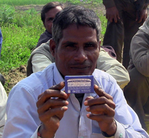 A peppermint farmer in India holds up one of the final products he supplies mint for